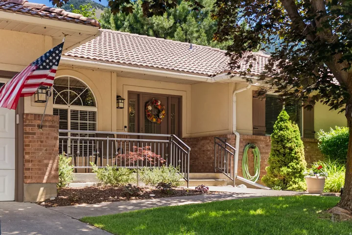 Front exterior featuring a tiled roof, stucco siding, and brick accents
