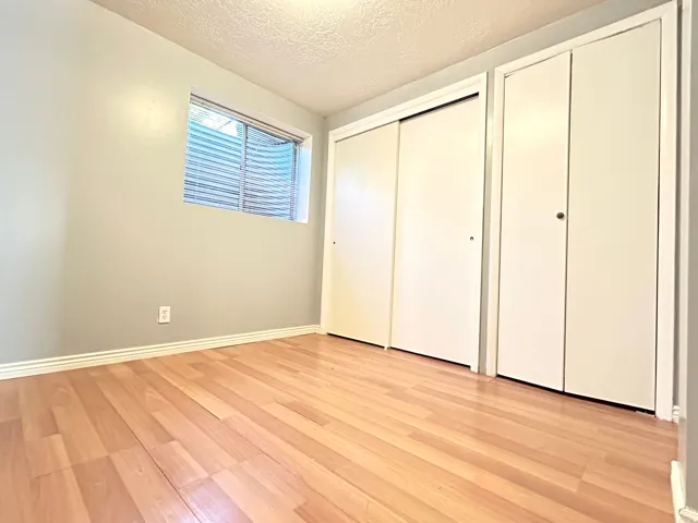 Room featuring light wood-finish flooring, light gray wall paint, and white baseboards
