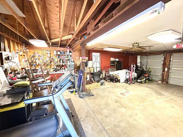 Spacious garage featuring exposed wood beam ceilings and dual roll-up doors