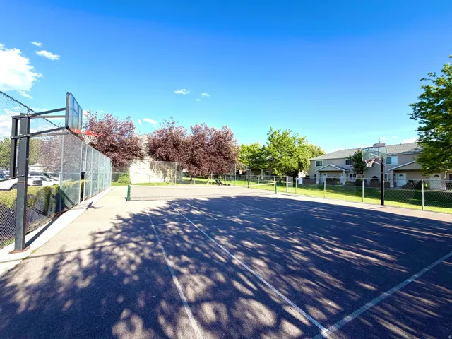 Outdoor multi-sport court featuring a basketball hoop and net