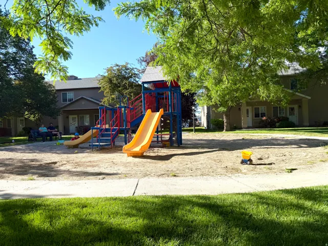 Central playground featuring multiple slides and climbing structures on a sand base
