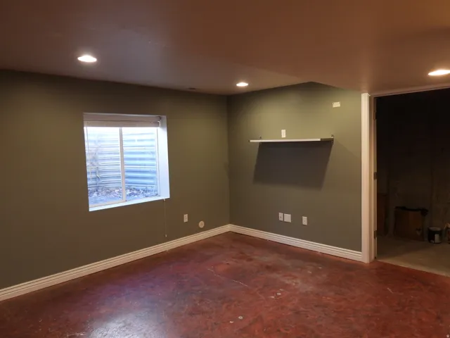 Spacious room featuring a single window, recessed lighting, and a built-in floating shelf