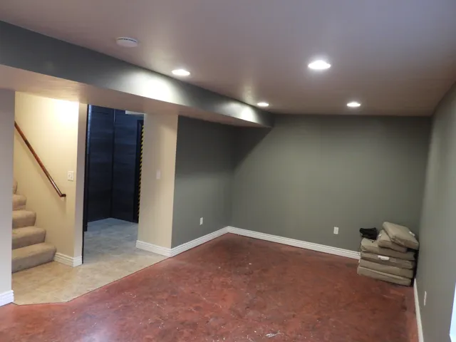 Spacious room featuring recessed lighting, a neutral wall palette, and a stained concrete floor