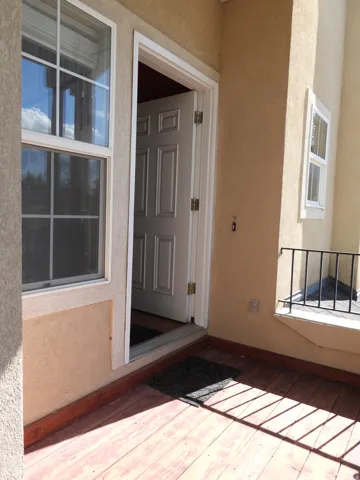 Entryway featuring a panel door, dual pane windows, and a wood-finish floor