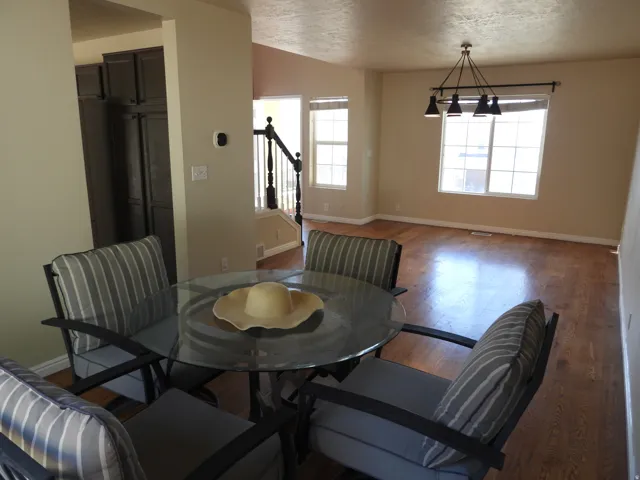 Bright interior space featuring wood-finish flooring, neutral-toned walls, and multiple windows