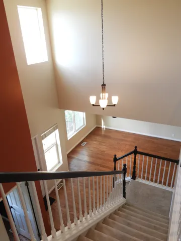 Two-story foyer with high ceilings, featuring a contemporary chandelier