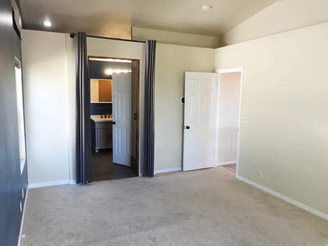 Carpeted interior space with a vaulted ceiling and recessed lighting