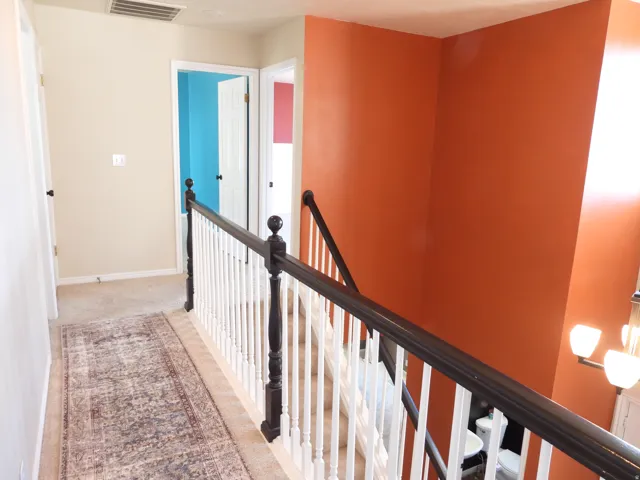 Hallway with neutral carpeting and beige painted walls