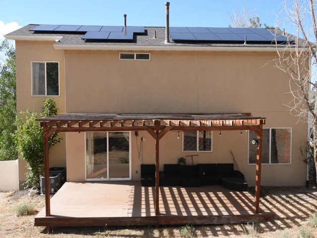 Rear exterior featuring a wood-finish deck with an attached pergola