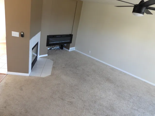 Living area with neutral tone carpet flooring and light beige wall paint