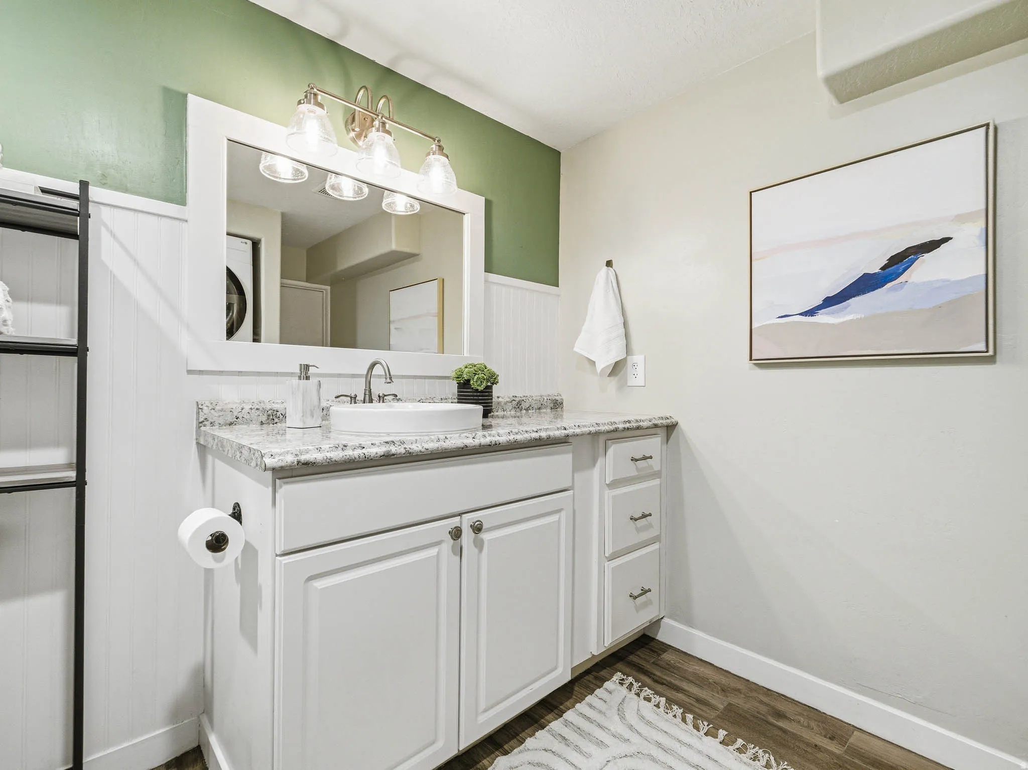 Bathroom featuring a white vanity with granite-style countertop, vessel sink, and brushed nickel faucet