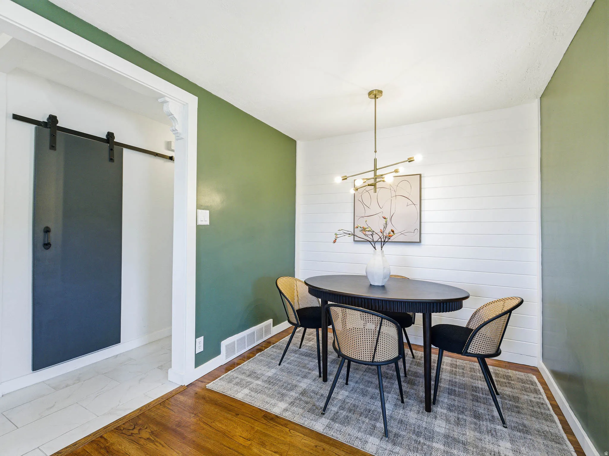 Dining area featuring wood-finish flooring and a contemporary chandelier