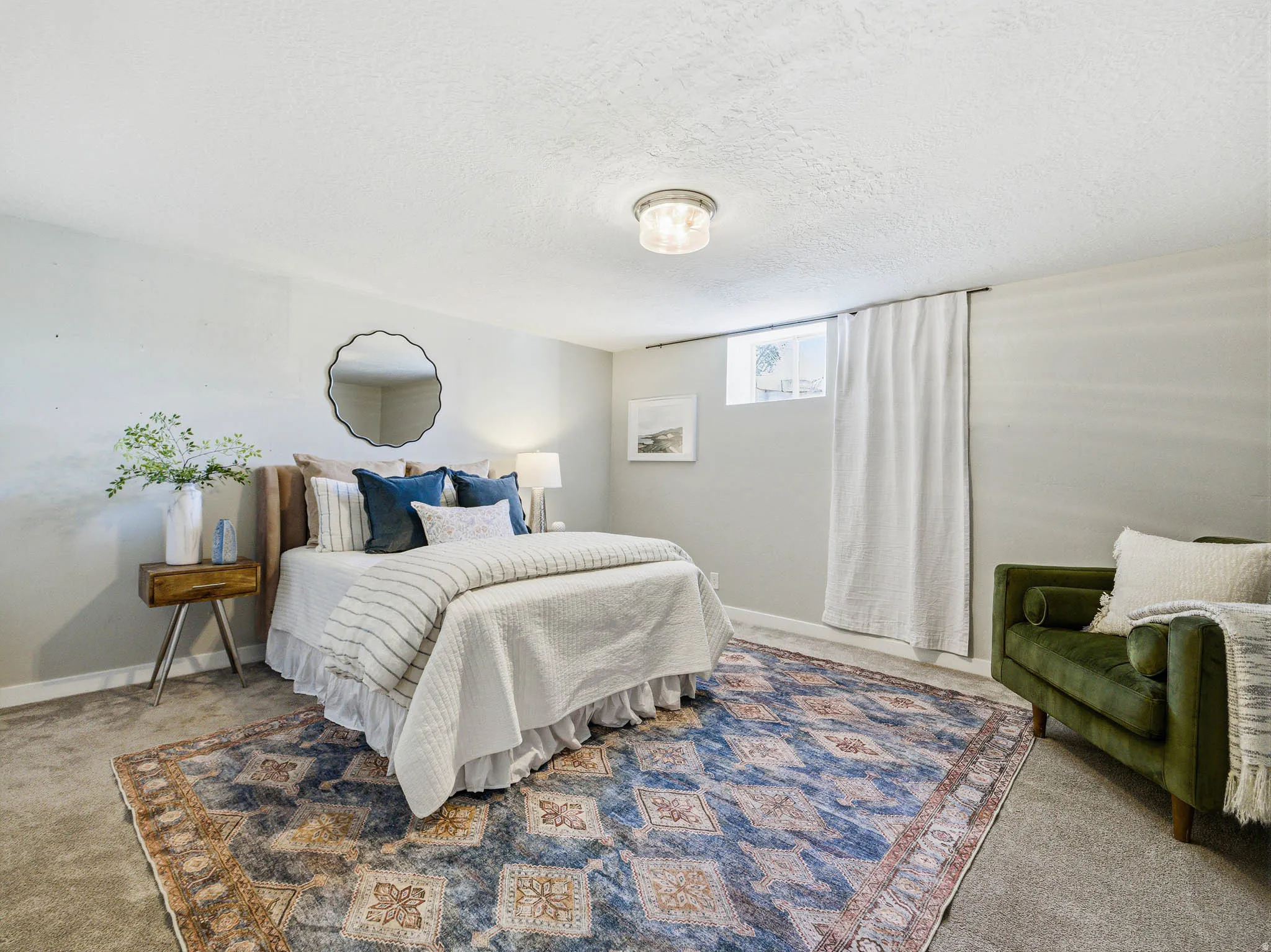 Bedroom featuring light gray walls, carpet flooring, a flush-mount ceiling light fixture, and a window with white curtains