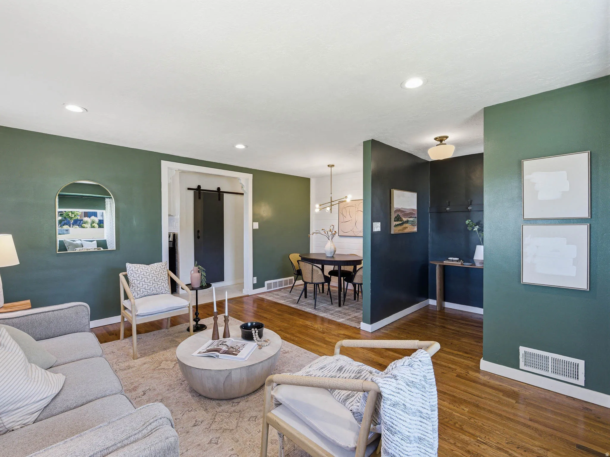 Open-concept living area with hardwood-finish flooring, recessed lighting, and a modern barn door