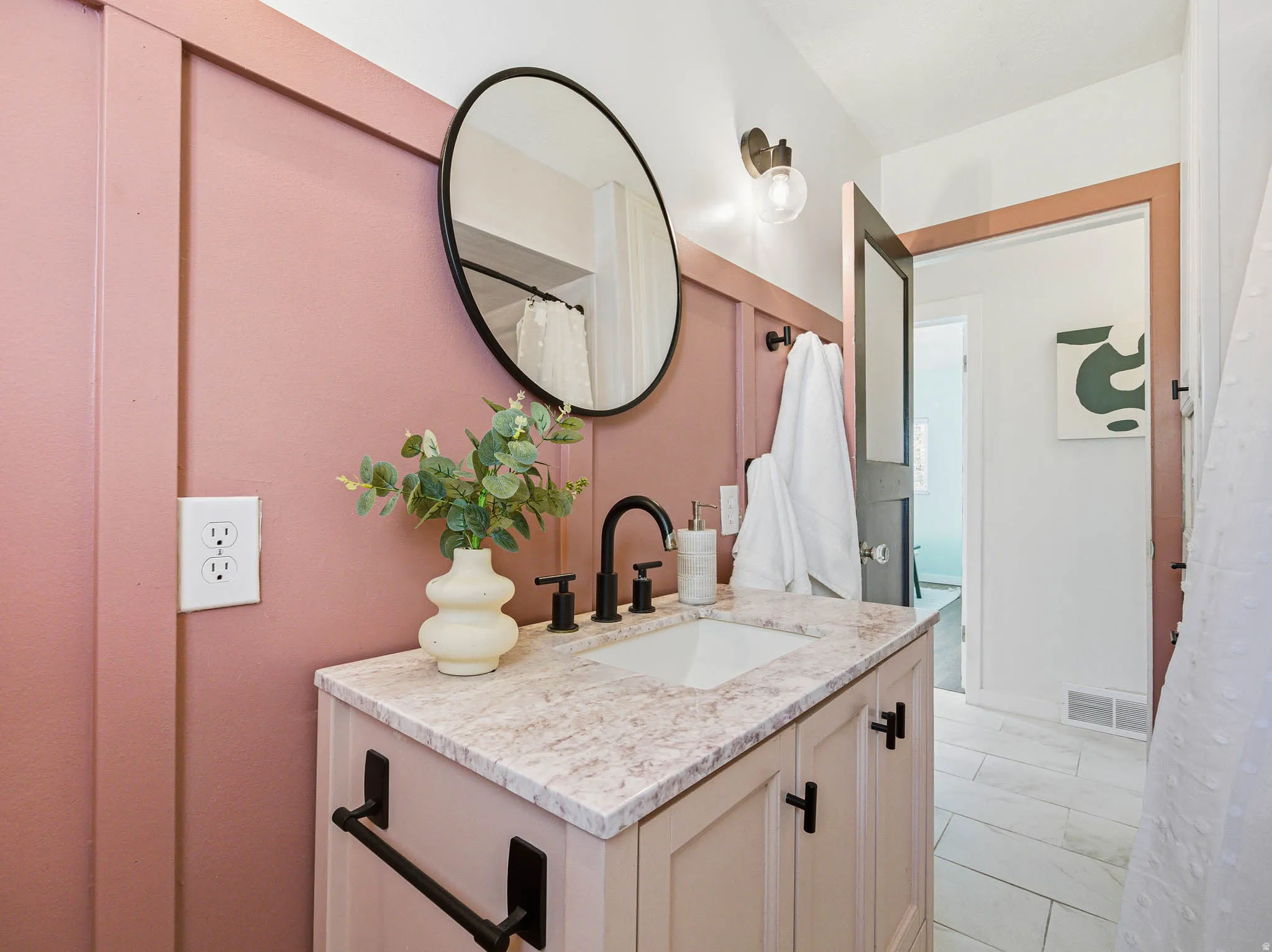 Modern bathroom vanity featuring a light-colored countertop with an integrated sink and matte black fixtures