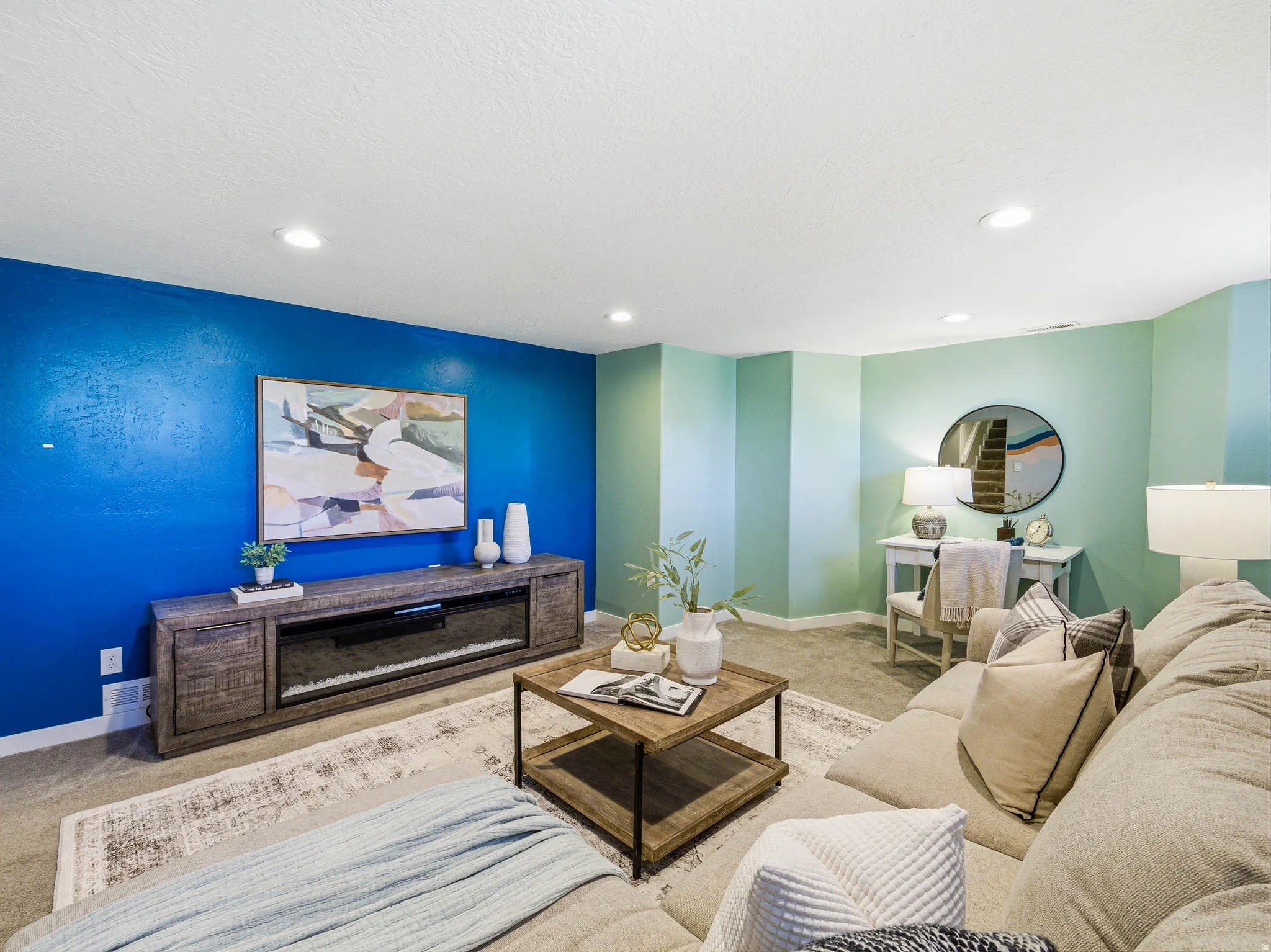 Living area featuring recessed lighting, carpet flooring, a built-in media console with an electric fireplace, and a light-toned area rug