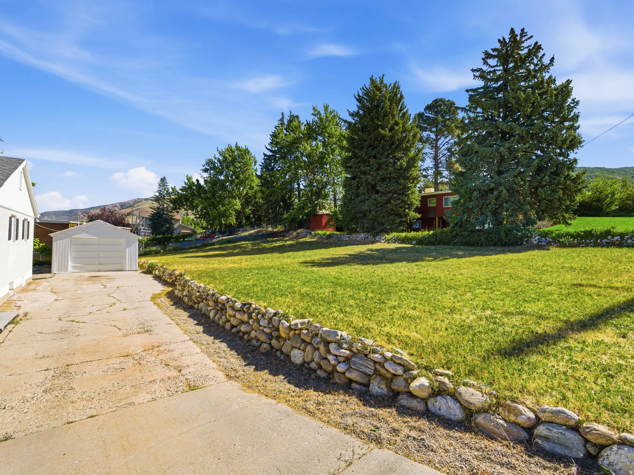 Expansive grassy yard defined by a stone retaining wall