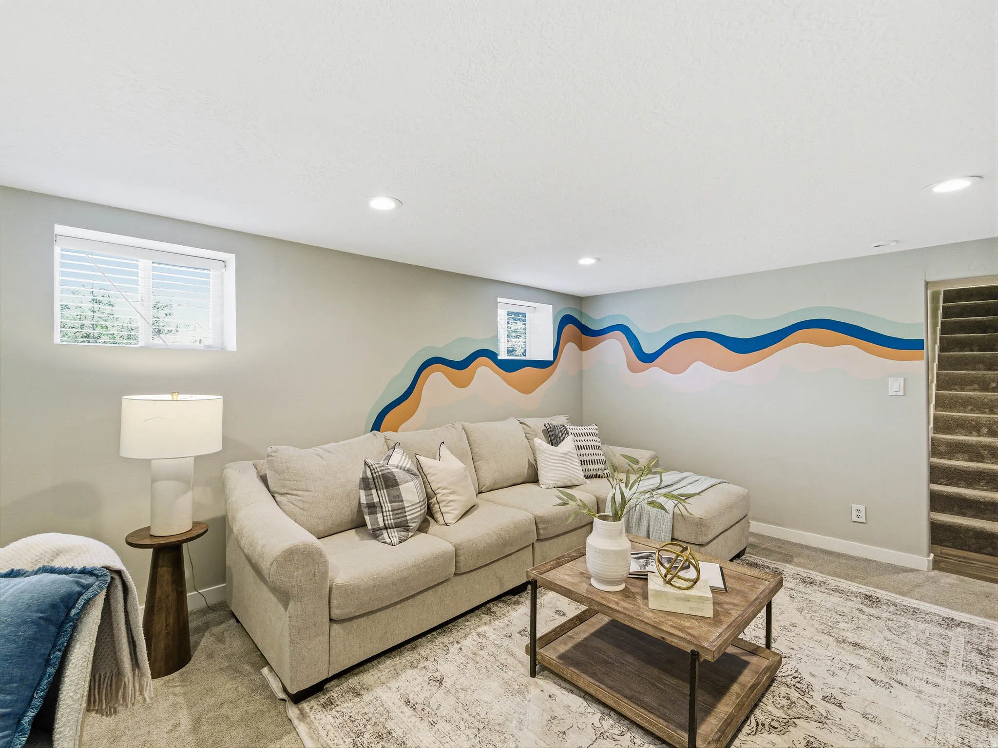 Finished living area featuring recessed lighting, a modern mural accent wall, a window, and carpeted flooring