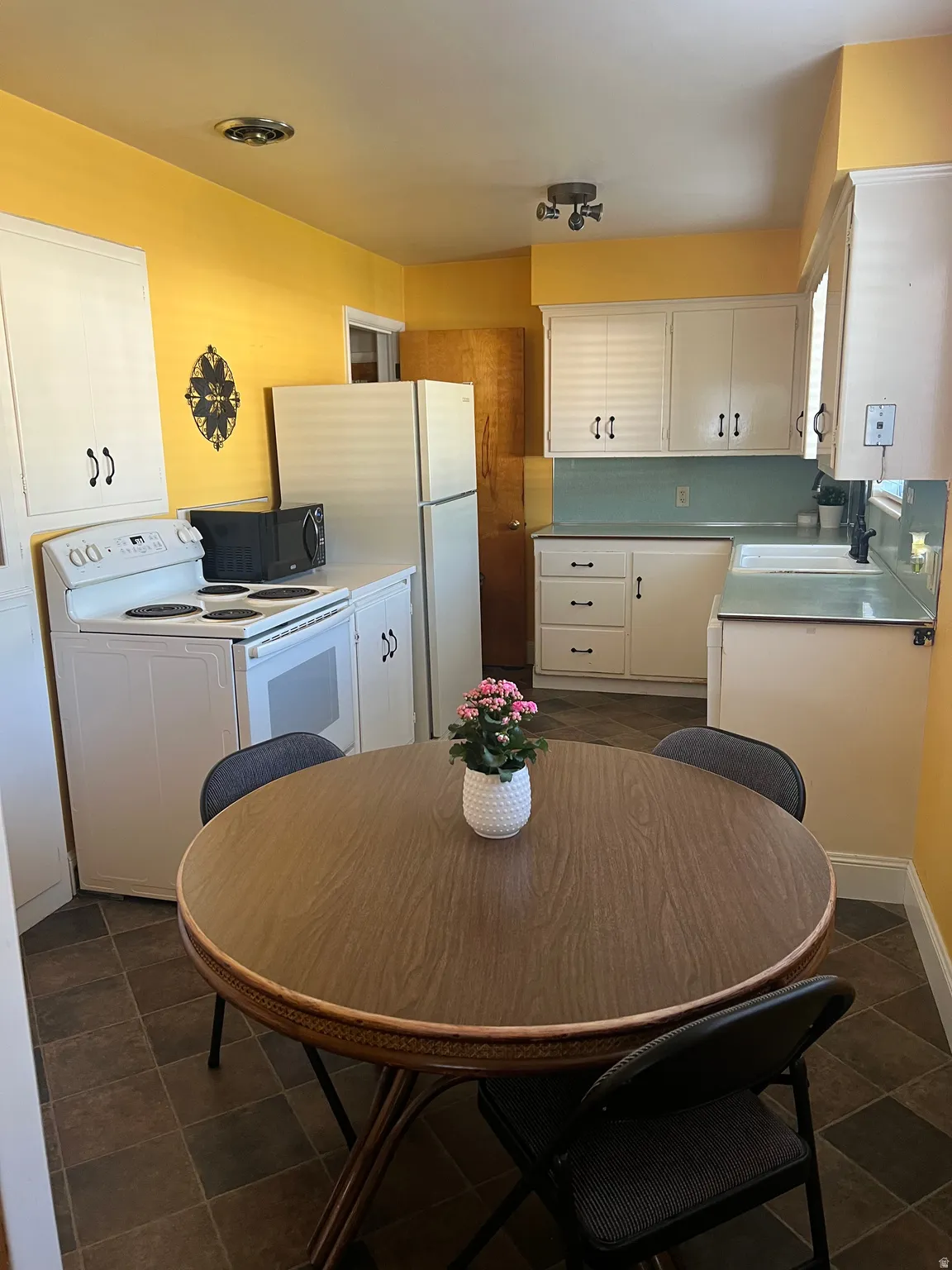Kitchen featuring white cabinetry, a tiled backsplash, and patterned floor tiling