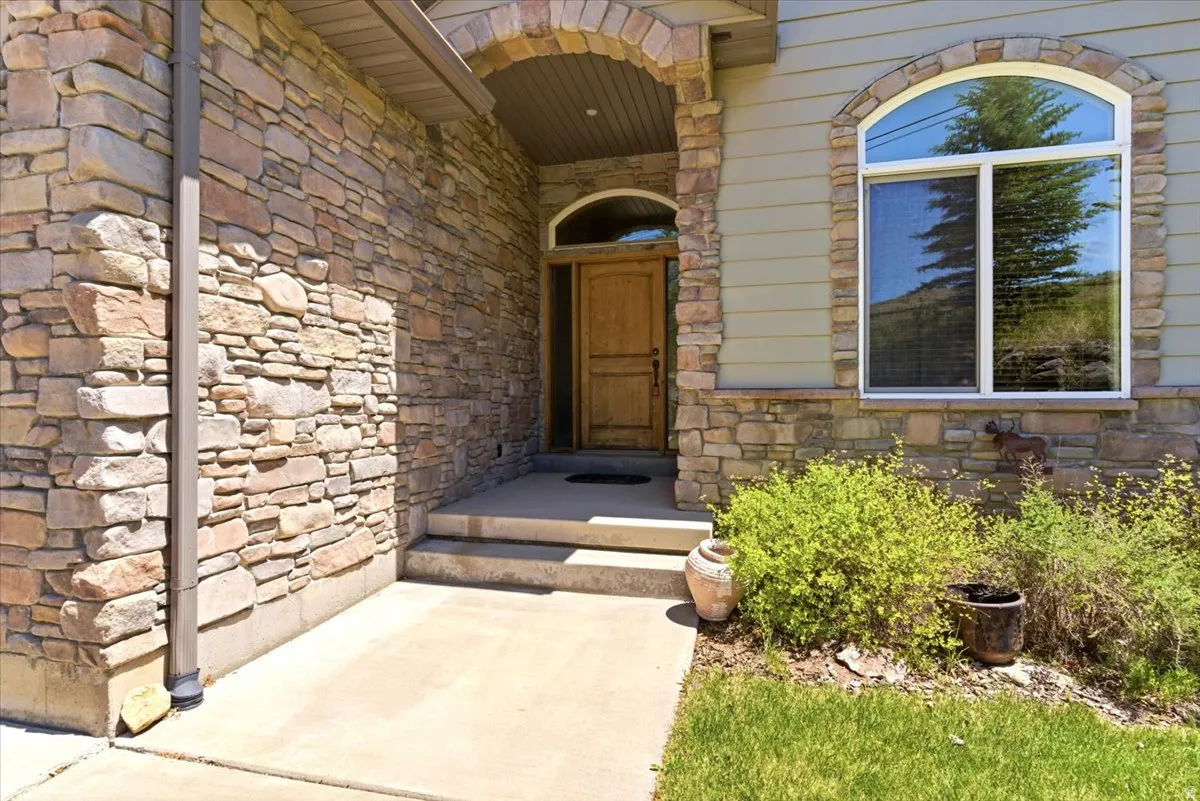 Stone veneer exterior with an arched entryway, complemented by a solid wood front door