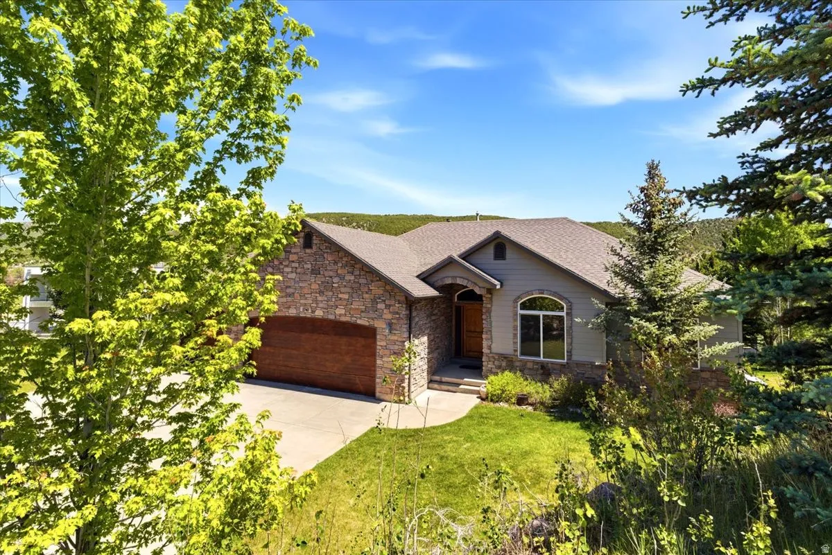 Stone and siding exterior with a wood-finish garage door