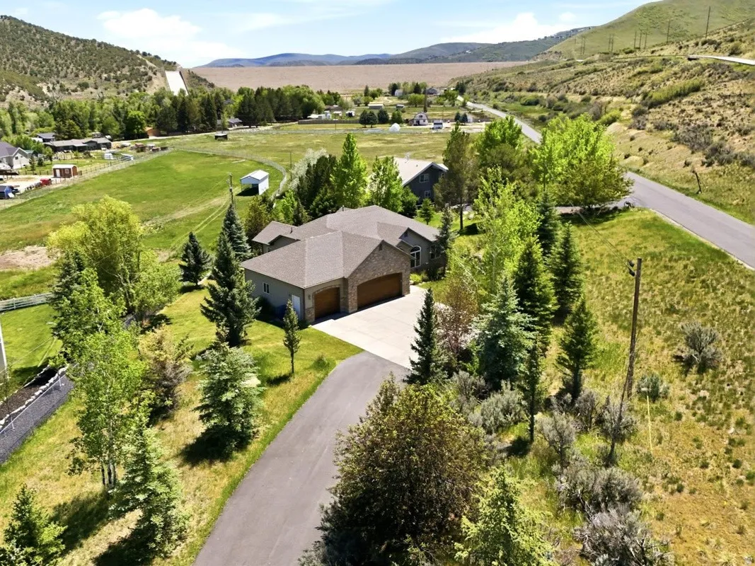 Contemporary residence with a multi-car garage, surrounded by mature trees and natural landscaping