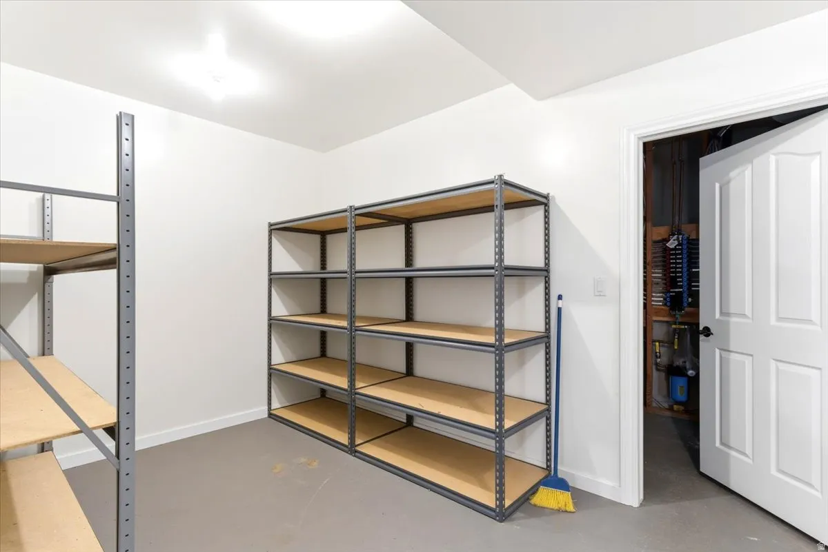 Dedicated storage room featuring two industrial-style shelving units, painted white walls, and a light gray floor