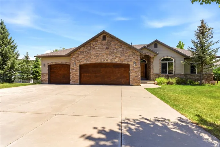 Stone facade residence with a two-car garage featuring wood-finish doors