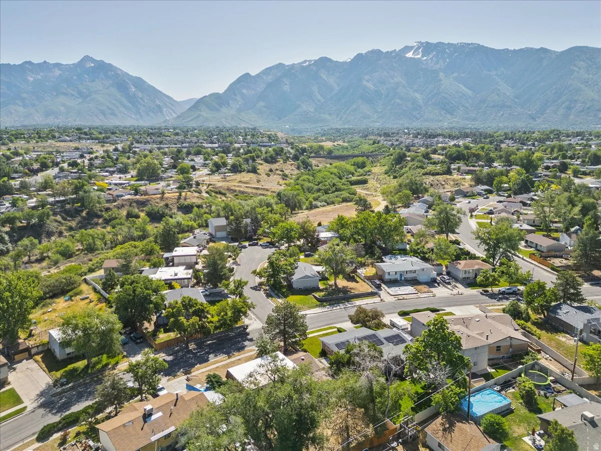 Expansive mountain range backdrop framing a residential area with varied rooflines and mature trees
