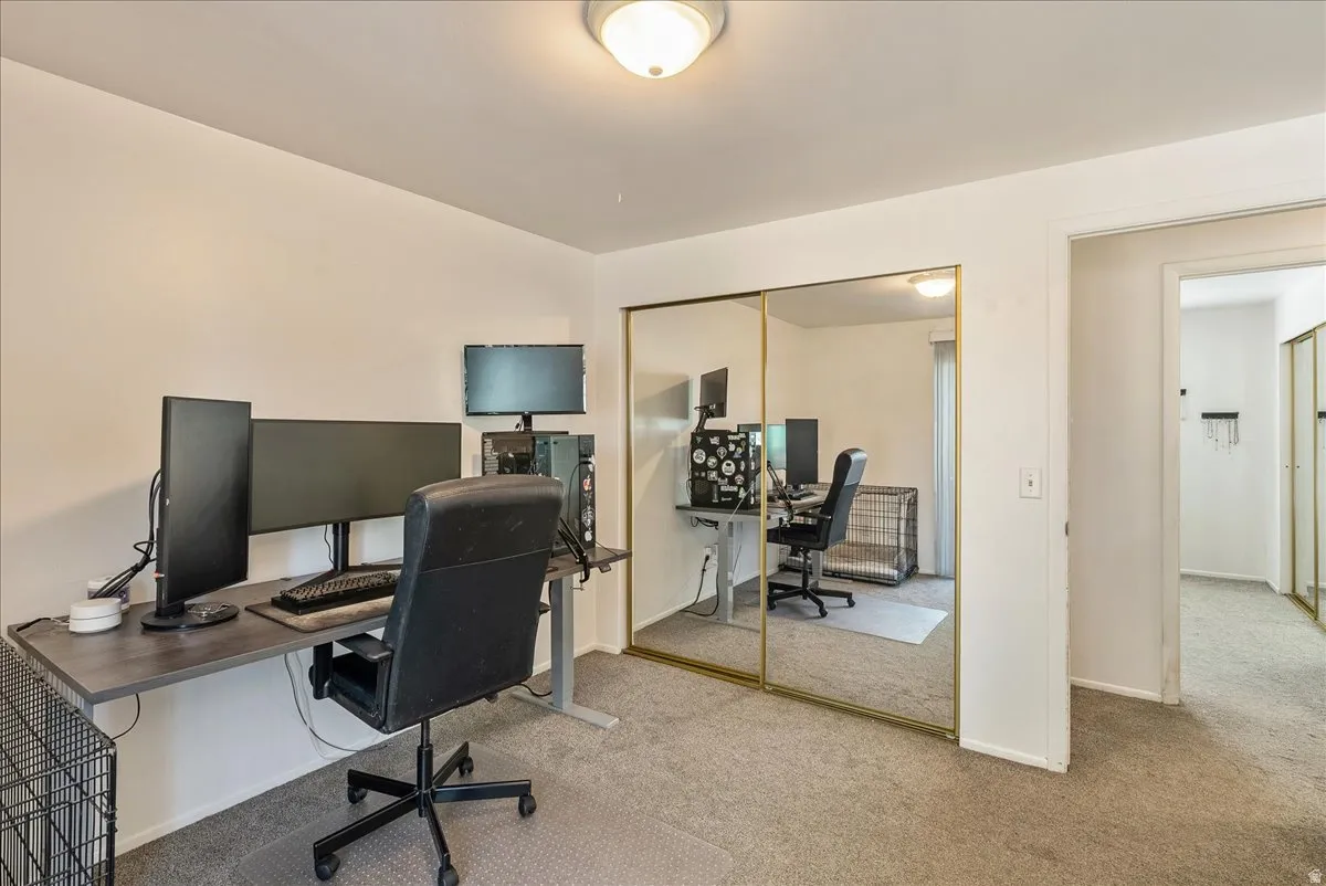 Room featuring neutral carpeting, a semi-flush ceiling light fixture, and a mirrored sliding closet door