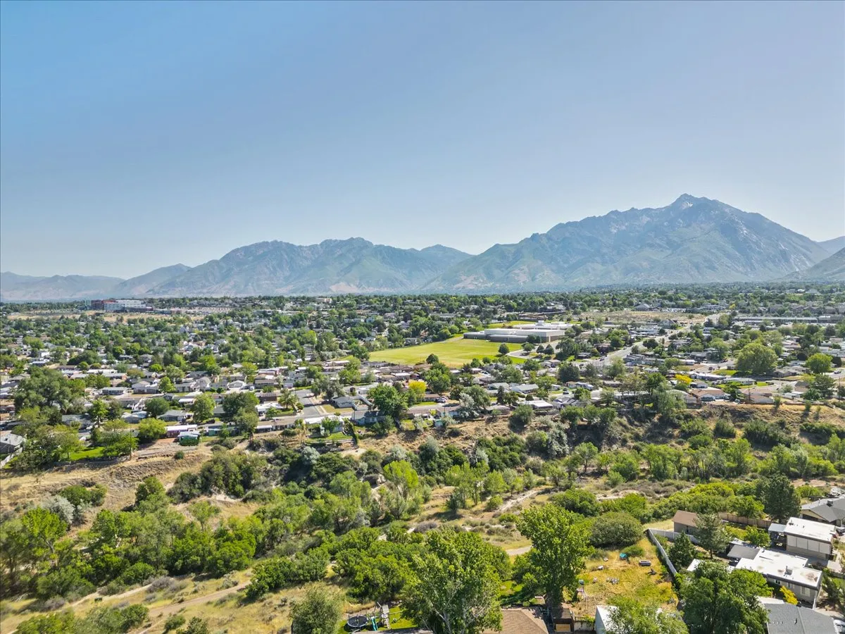 Expansive neighborhood setting featuring a mountainous backdrop, abundant green spaces, and established residential areas