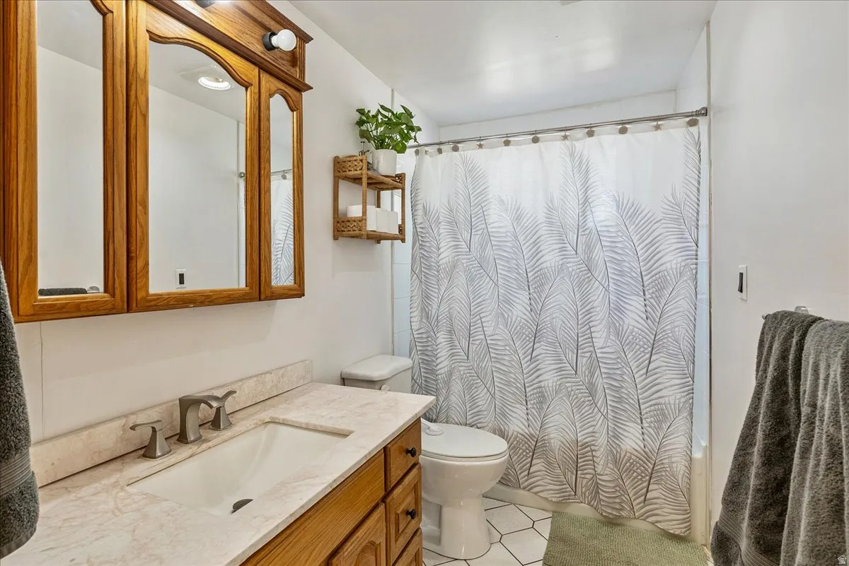 Bathroom featuring a light wood-finish vanity with a built-in sink, a coordinating medicine cabinet, and a shower/tub combination with a white subway tile surround