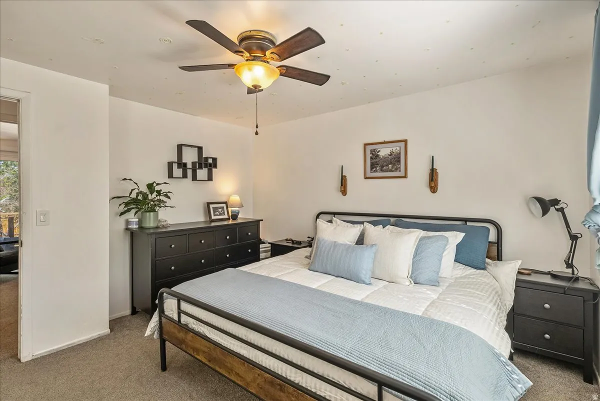 Bedroom featuring a ceiling fan with integrated lighting, recessed ceiling lights, and wall-mounted sconces