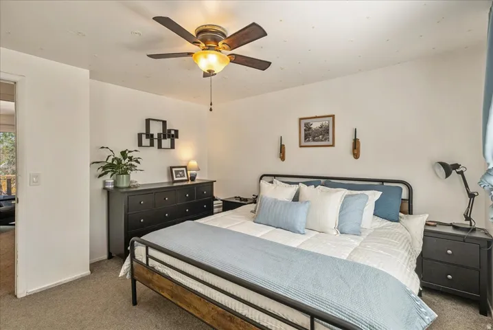 Bedroom featuring a ceiling fan with integrated lighting, recessed ceiling lights, and wall-mounted sconces
