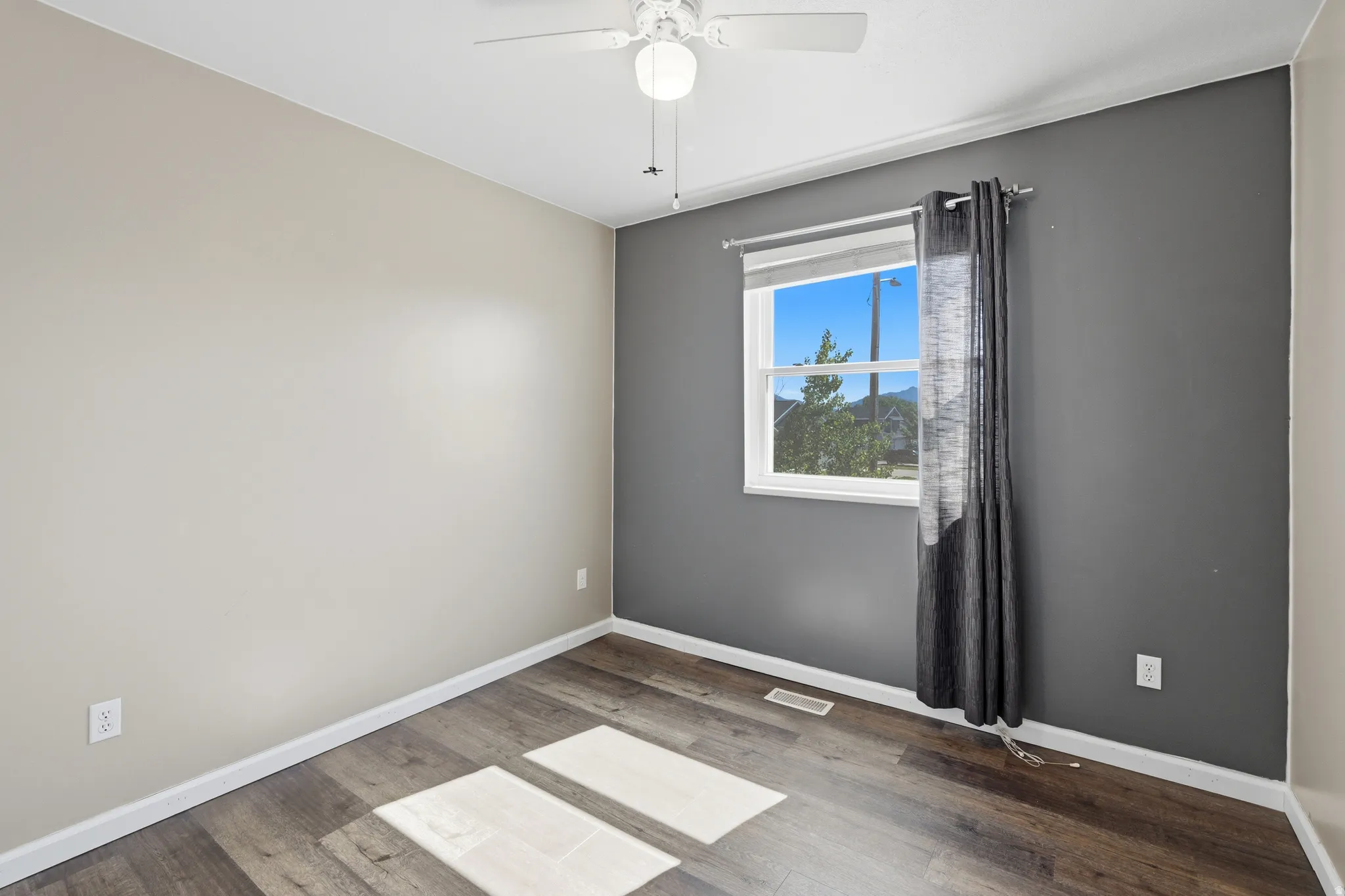 Interior room featuring wood-finish flooring and a ceiling fan