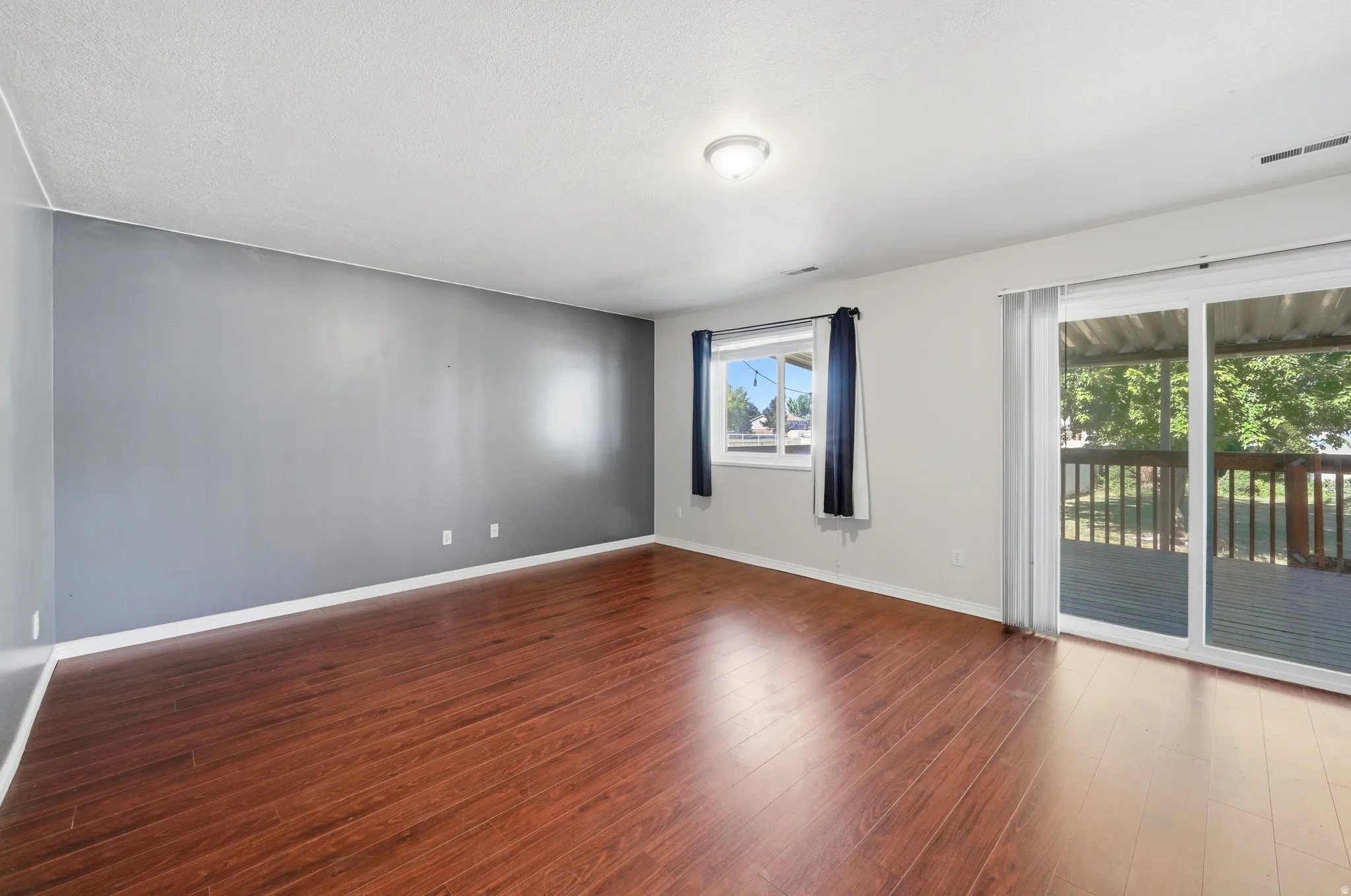 Spacious room featuring wood-finish flooring and a neutral color palette