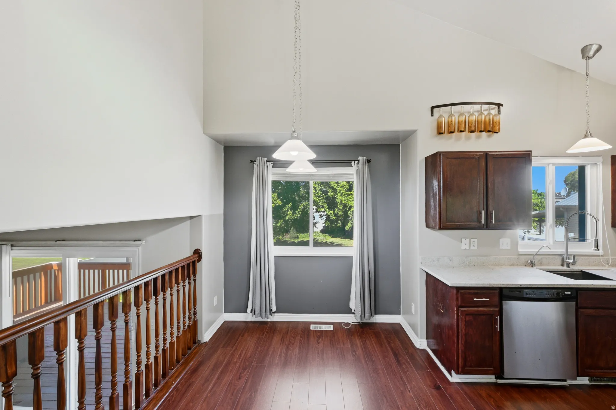 Kitchen area featuring dark wood-finish cabinetry, light-toned countertops, and stainless steel appliances
