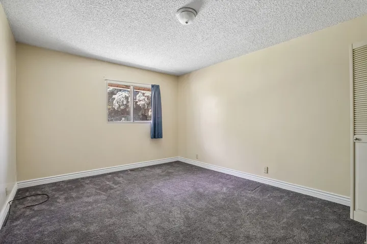 Room featuring neutral wall paint, grey carpeting, and white baseboards
