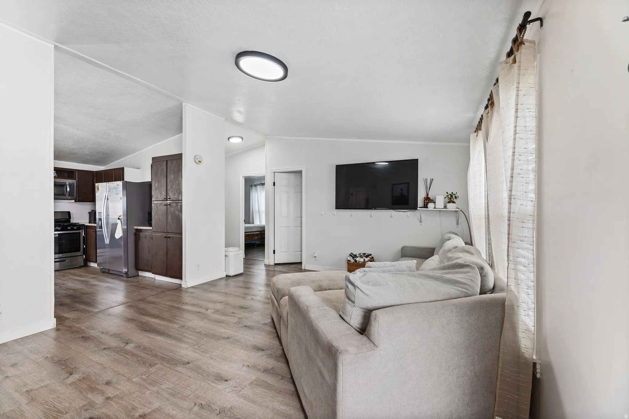 Open-concept living area featuring wood-finish flooring, recessed lighting, and light-toned walls