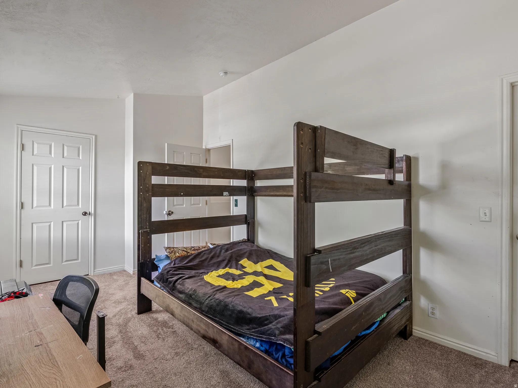 Spacious room featuring neutral carpet flooring, white painted walls, and white paneled doors