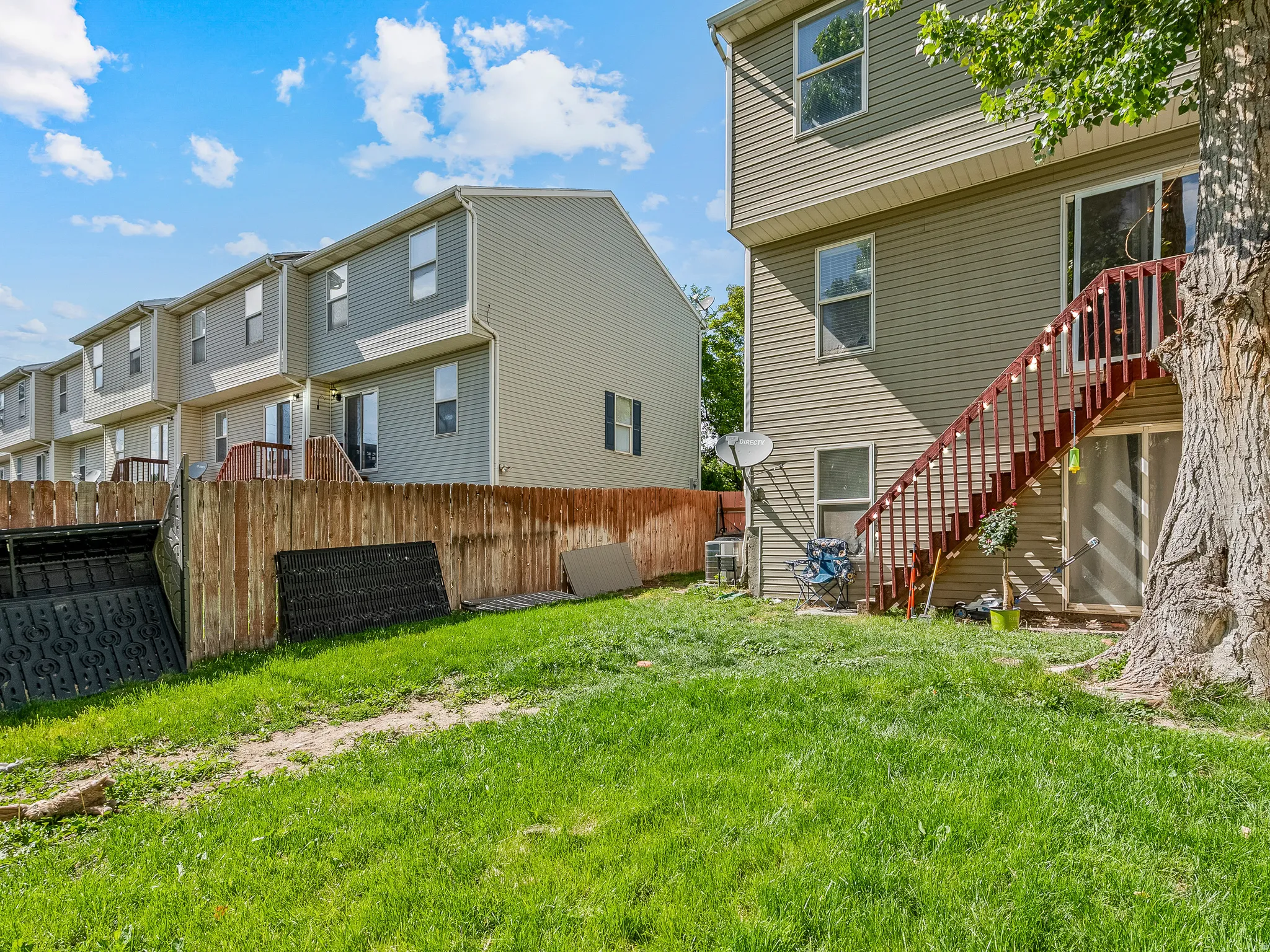 Rear exterior with vinyl siding and a wooden privacy fence