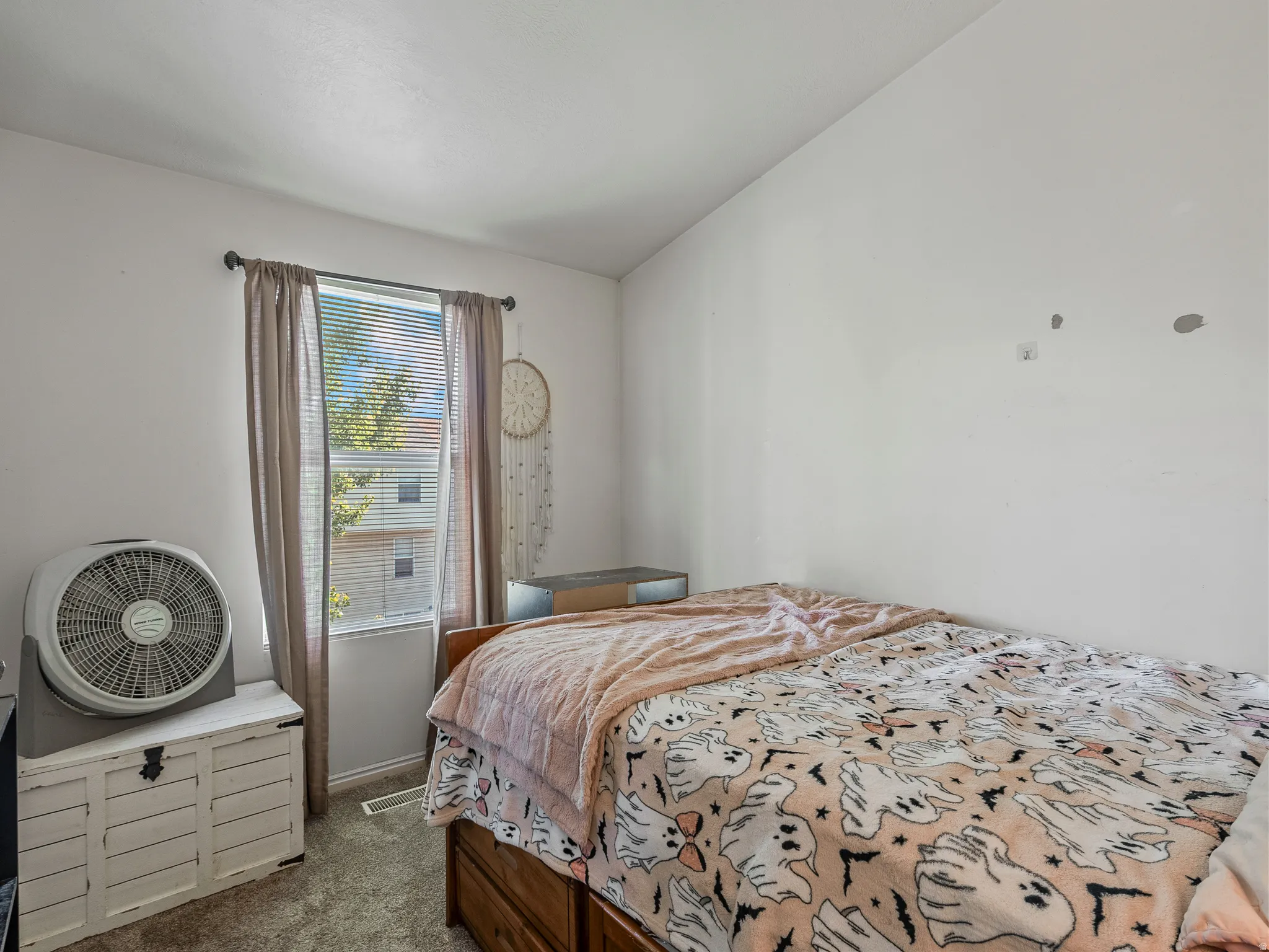 Carpeted interior space featuring a window with horizontal blinds, a neutral wall finish, and a ceiling with a textured finish