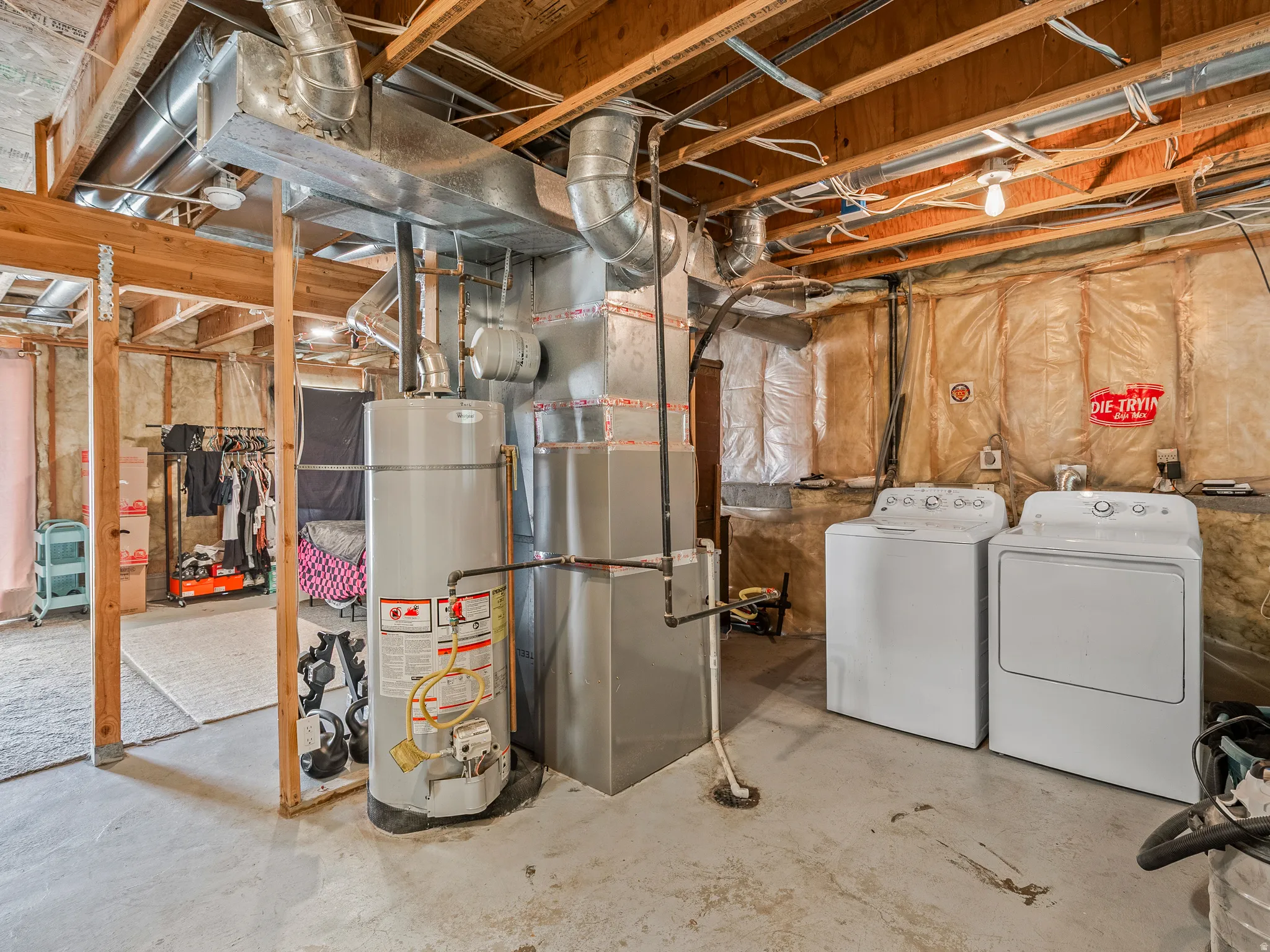 Utility area featuring exposed wood ceiling joists, ductwork, and mechanical systems
