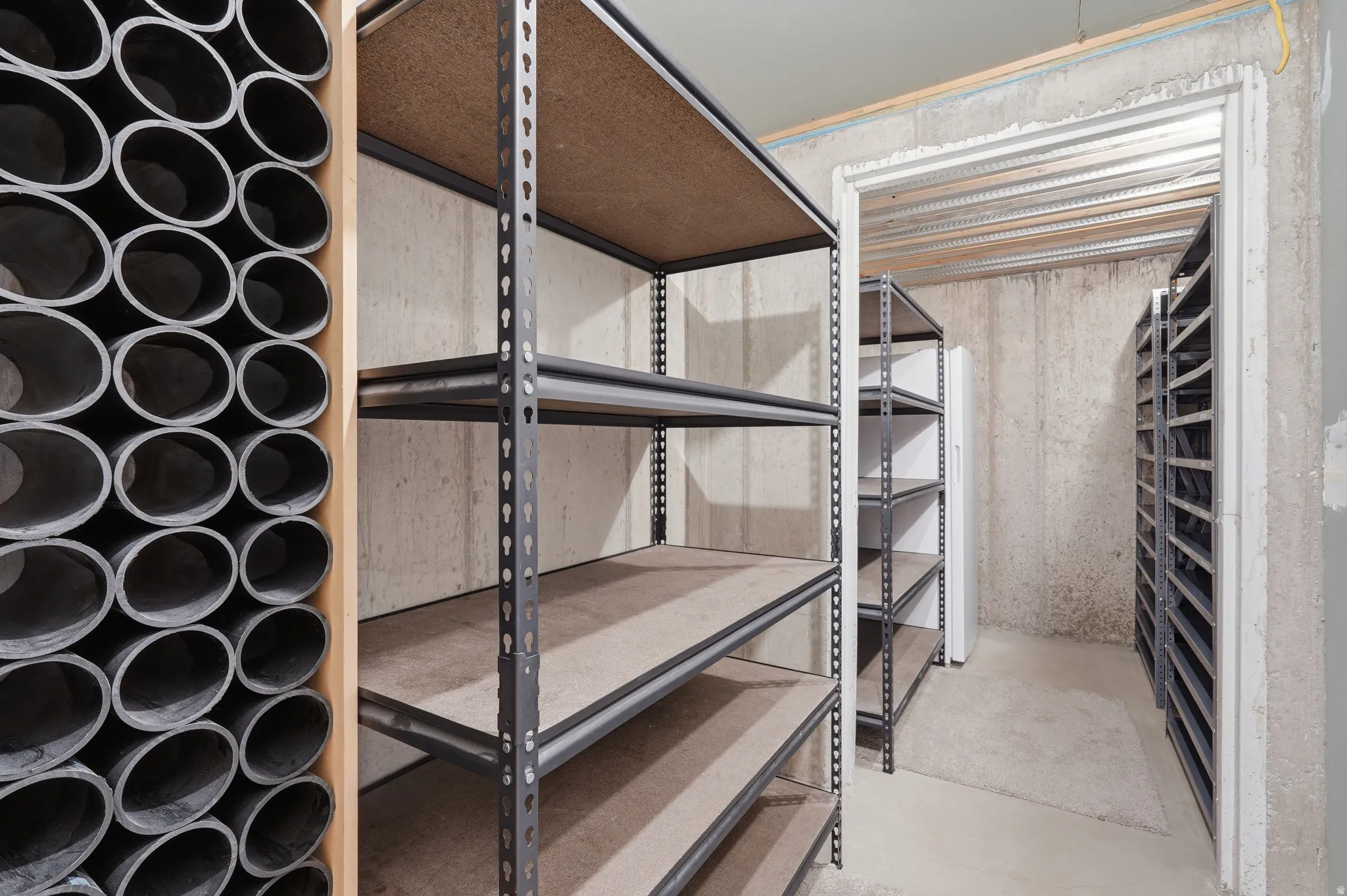 Dedicated storage area featuring multiple units of industrial-style shelving with particle board surfaces