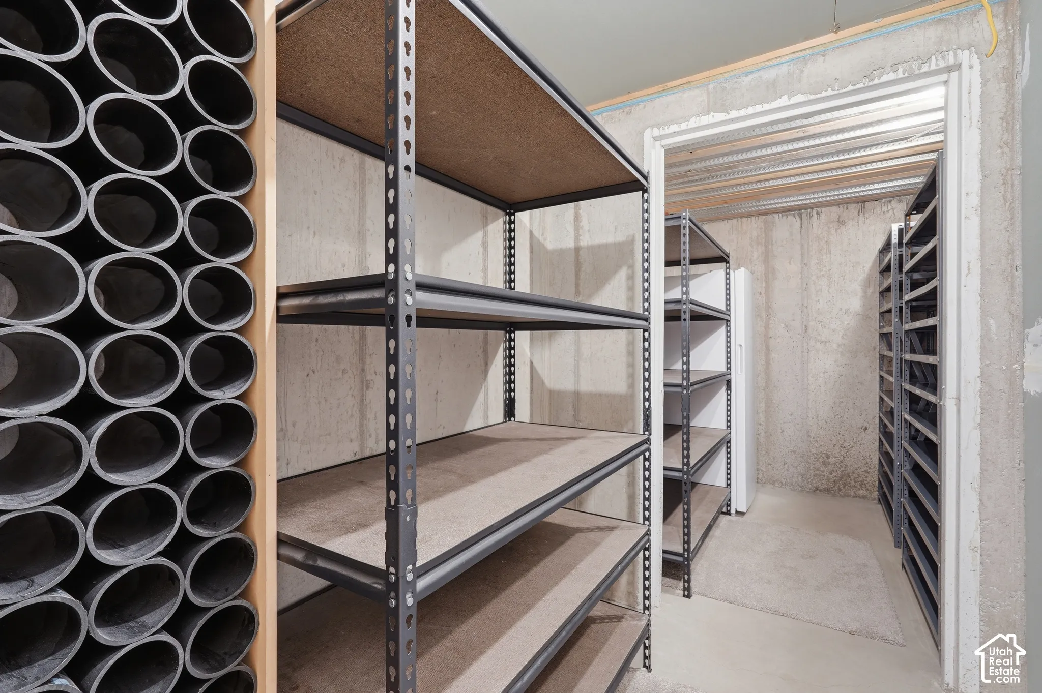 Dedicated storage area featuring multiple units of industrial-style shelving with particle board surfaces