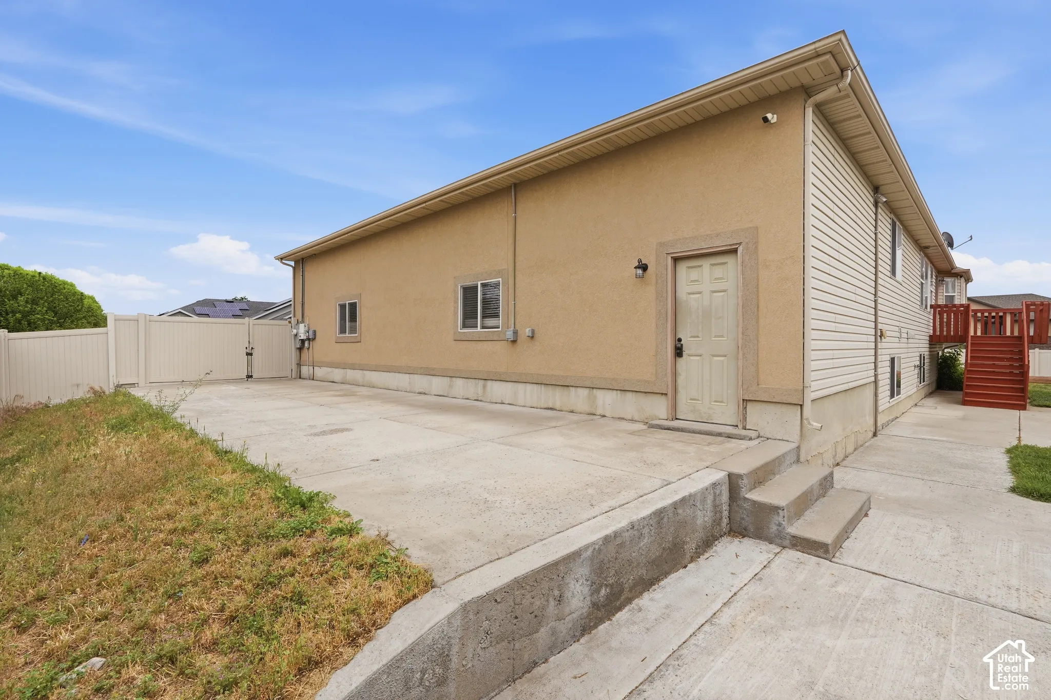 Exterior featuring a stucco and siding finish, concrete patio, and a privacy fence