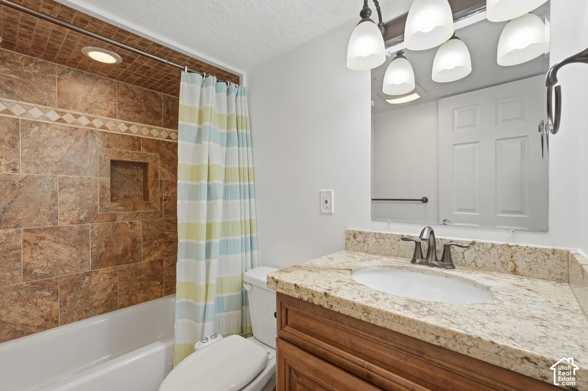 Full bathroom featuring a tub-shower combination with brown tile surround and an integrated niche