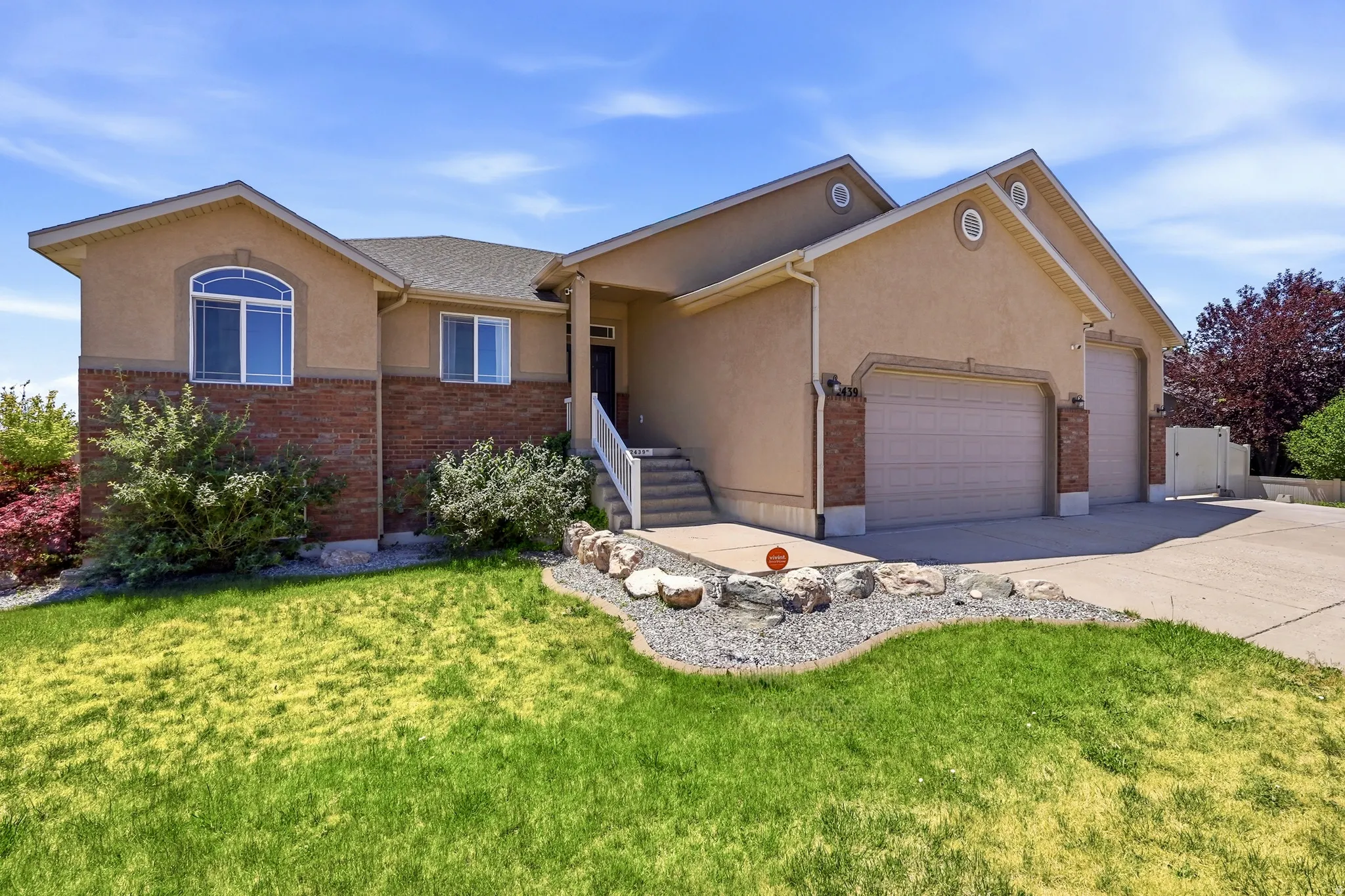 Stucco and brick exterior with a multi-car garage
