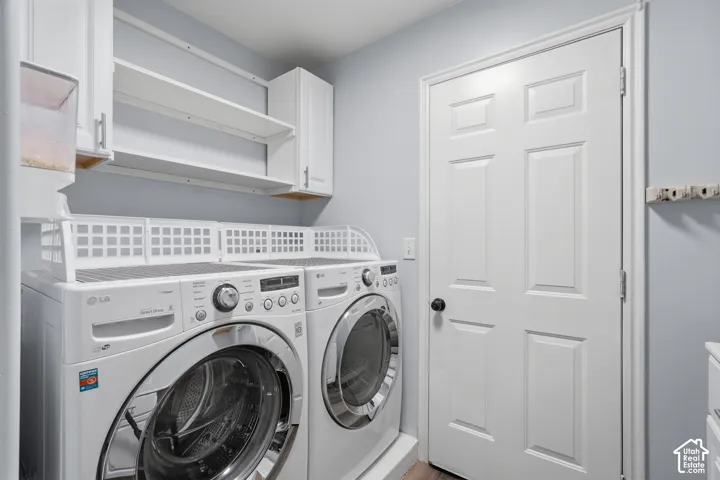 Laundry area featuring built-in cabinetry, open shelving, and wood-finish flooring
