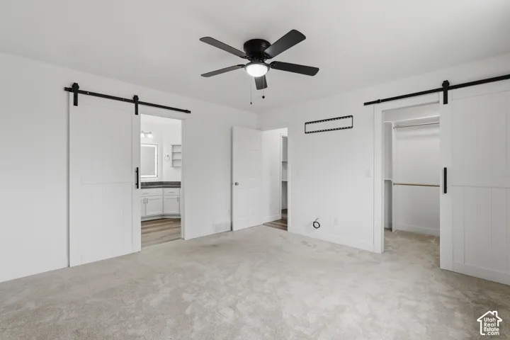 Spacious room featuring light gray carpeting and white walls